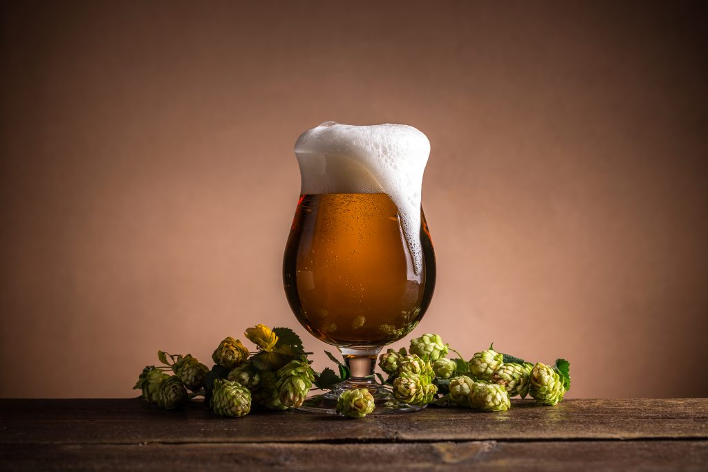 Glass,Of,Beer,With,Hops,On,Vintage,Wooden,Board